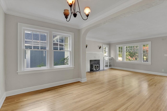8 W 26th Ave, Spokane, WA 99203 - unfurnished living room featuring arched walkways, light wood finished floors, a chandelier, and crown molding
