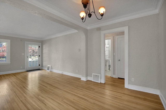 8 W 26th Ave, Spokane, WA 99203 - spare room featuring light wood-style flooring, ornamental molding, a chandelier, and arched walkways