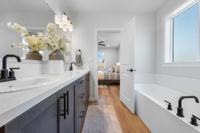 1714 S Moen St Unit 2/1Umpqua, Spokane Valley, WA 99016 - ensuite bathroom featuring wood finished floors, double vanity, and a garden tub