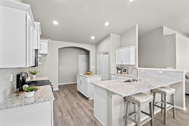 18126 E Barclay Ct Unit 3/4Snowbrush, Spokane Valley, WA 99016 - kitchen with arched walkways, stainless steel appliances, decorative backsplash, a center island, and vaulted ceiling