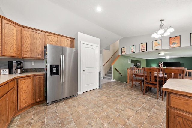 4031 S Bates Rd, Spokane Valley, WA 99206 - kitchen featuring stainless steel refrigerator with ice dispenser, vaulted ceiling, brown cabinets, a chandelier, and stone finish flooring