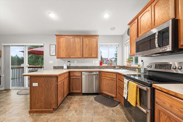 4031 S Bates Rd, Spokane Valley, WA 99206 - kitchen featuring appliances with stainless steel finishes, a peninsula, brown cabinetry, light countertops, and recessed lighting