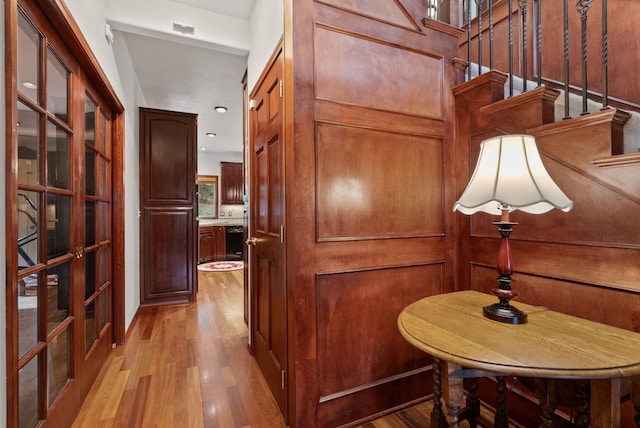 12910 S Fairway Ridge Ln, Spokane, WA 99224 - hallway with light wood finished floors, french doors, and stairway