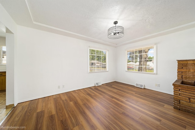 1306 W Joseph Ave, Spokane, WA 99205 - unfurnished living room featuring a chandelier, wood finished floors, plenty of natural light, and a textured ceiling