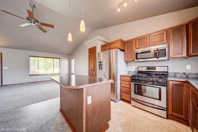 20051 E Meyers Ave, Liberty Lake, WA 99019 - kitchen with appliances with stainless steel finishes, light colored carpet, lofted ceiling, brown cabinetry, and a ceiling fan