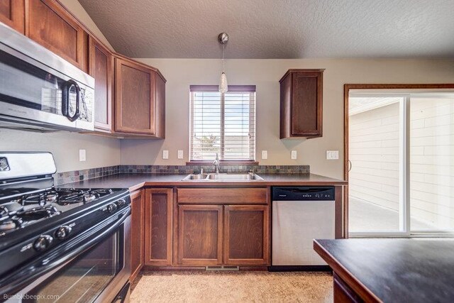 20051 E Meyers Ave, Liberty Lake, WA 99019 - kitchen with stainless steel appliances, dark countertops, a textured ceiling, and hanging light fixtures