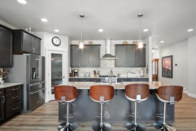 2630 S Fairmont Estates Ct, Greenacres, WA 99016 - kitchen with wall chimney range hood, stainless steel fridge with ice dispenser, light wood-style floors, decorative backsplash, and recessed lighting