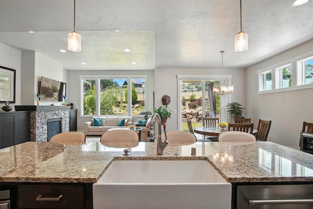 2630 S Fairmont Estates Ct, Greenacres, WA 99016 - kitchen featuring dishwasher, open floor plan, recessed lighting, a stone fireplace, and light stone counters