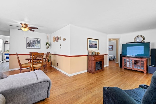 5204 N Belt St, Spokane, WA 99205 - living room featuring wood finished floors, a ceiling fan, and a glass covered fireplace