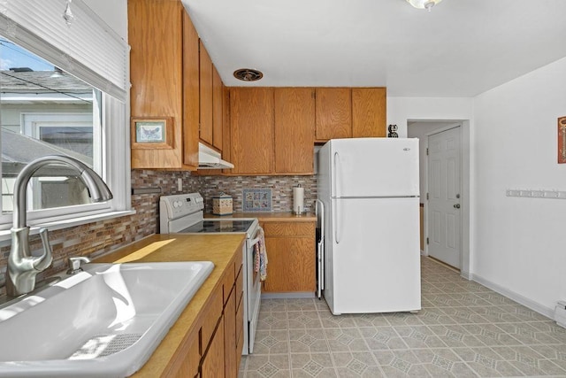 5204 N Belt St, Spokane, WA 99205 - kitchen featuring white appliances, under cabinet range hood, brown cabinetry, decorative backsplash, and light countertops