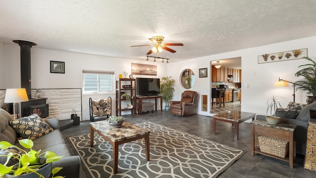 3908 E 26th Ave, Spokane, WA 99223 - living room with a wood stove, a textured ceiling, ceiling fan, and track lighting