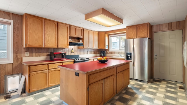 3908 E 26th Ave, Spokane, WA 99223 - kitchen featuring stainless steel refrigerator with ice dispenser, wood walls, black / electric stove, light floors, and under cabinet range hood