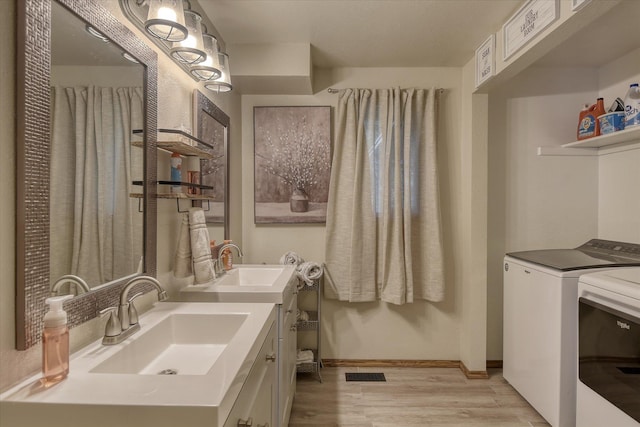 12720 E Kiowa Ct, Spokane Valley, WA 99206 - bathroom featuring washer and dryer, wood finished floors, and vanity