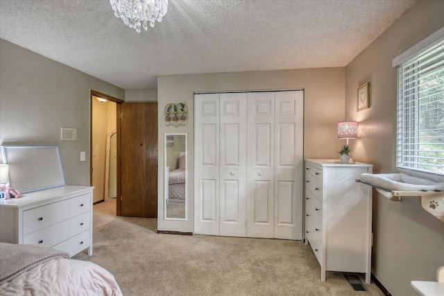 12720 E Kiowa Ct, Spokane Valley, WA 99206 - bedroom featuring light colored carpet, a closet, a textured ceiling, and a chandelier