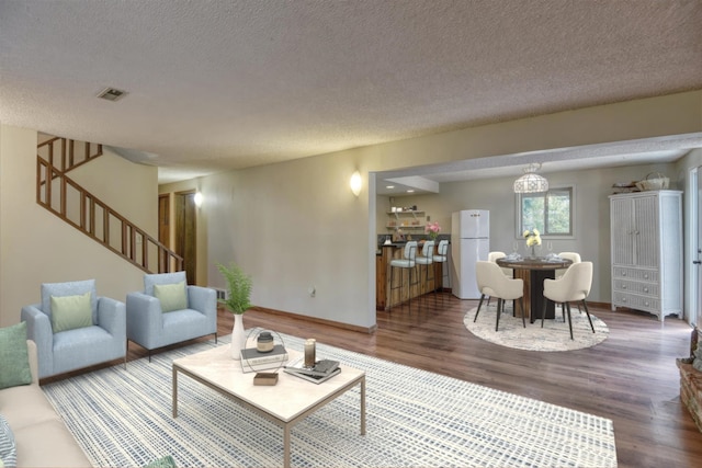 12720 E Kiowa Ct, Spokane Valley, WA 99206 - living area featuring a textured ceiling, wood finished floors, and stairway