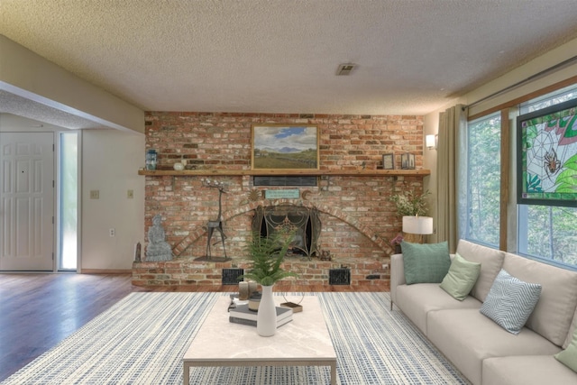 12720 E Kiowa Ct, Spokane Valley, WA 99206 - living room featuring a textured ceiling, healthy amount of natural light, wood finished floors, a brick fireplace, and brick wall