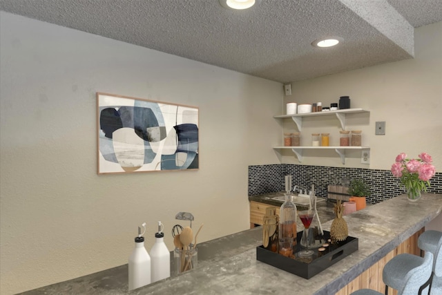 12720 E Kiowa Ct, Spokane Valley, WA 99206 - kitchen featuring a textured ceiling, decorative backsplash, a breakfast bar, and recessed lighting