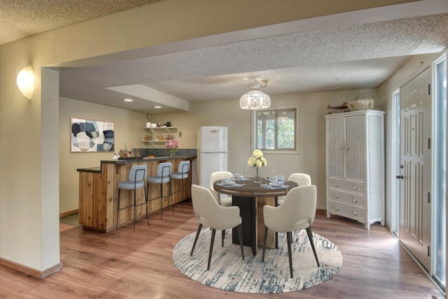 12720 E Kiowa Ct, Spokane Valley, WA 99206 - dining space featuring light wood-style floors and a textured ceiling