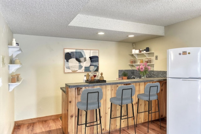 12720 E Kiowa Ct, Spokane Valley, WA 99206 - indoor bar featuring freestanding refrigerator, wood finished floors, a textured ceiling, and recessed lighting