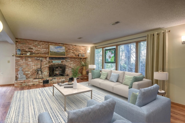 12720 E Kiowa Ct, Spokane Valley, WA 99206 - living area with wood finished floors, a textured ceiling, and a brick fireplace