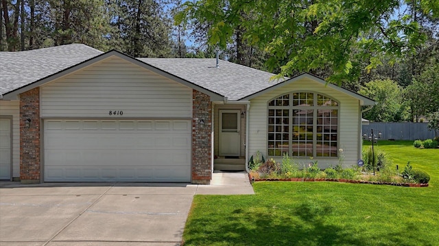 8410 N Pine Meadows Ln, Nine Mile Falls, WA 99026 - ranch-style home featuring a shingled roof, concrete driveway, a garage, a front yard, and brick siding