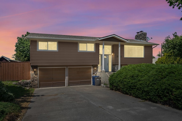 12925 E Valleyway Ave, Spokane Valley, WA 99216 - bi-level home with an attached garage, a chimney, driveway, and stone siding