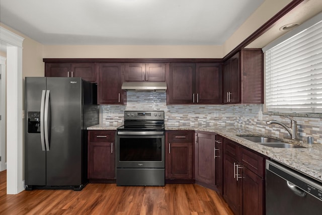 12925 E Valleyway Ave, Spokane Valley, WA 99216 - kitchen with appliances with stainless steel finishes, under cabinet range hood, wood finished floors, light stone countertops, and decorative backsplash