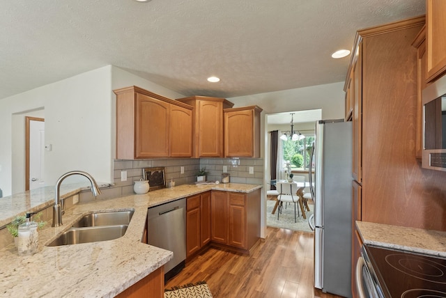 12919 E 39th Ln, Spokane Valley, WA 99206 - kitchen featuring appliances with stainless steel finishes, light wood-style flooring, tasteful backsplash, brown cabinets, and light stone countertops