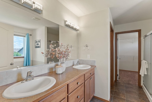 12919 E 39th Ln, Spokane Valley, WA 99206 - bathroom with double vanity, a stall shower, a walk in closet, and stone finish flooring