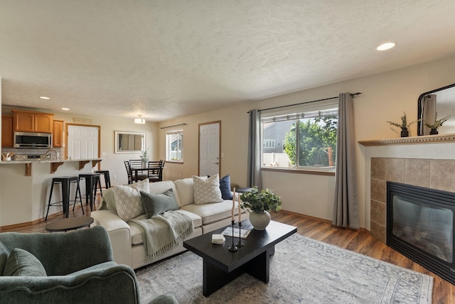 12919 E 39th Ln, Spokane Valley, WA 99206 - living area with healthy amount of natural light, light wood-style flooring, recessed lighting, a fireplace, and a textured ceiling