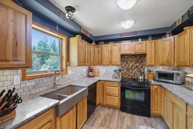 34225 N Arlington Ln, Deer Park, WA 99006 - kitchen with black appliances, light wood-style floors, light stone counters, and backsplash