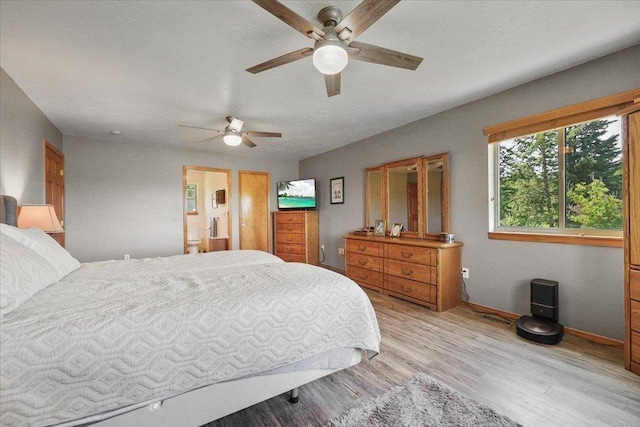34225 N Arlington Ln, Deer Park, WA 99006 - bedroom with light wood finished floors, ceiling fan, and ensuite bathroom