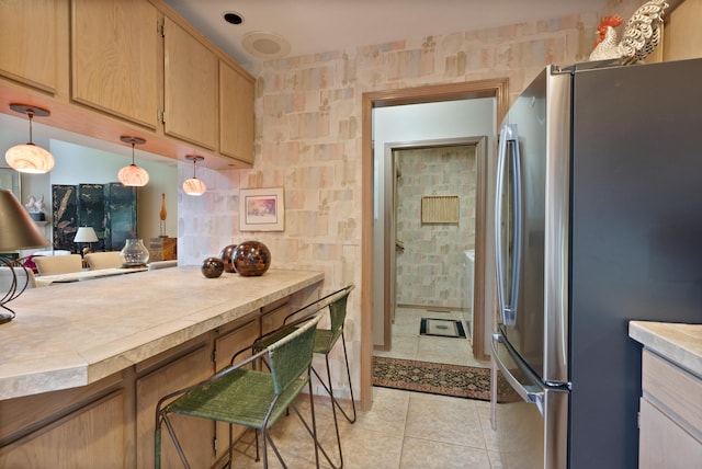 3001 S Winthrop Ln, Spokane, WA 99203 - kitchen featuring freestanding refrigerator, light tile patterned flooring, light countertops, light brown cabinetry, and hanging light fixtures
