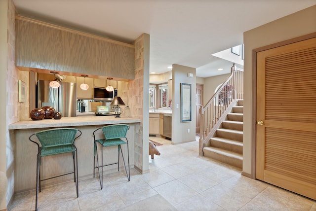 3001 S Winthrop Ln, Spokane, WA 99203 - kitchen with appliances with stainless steel finishes, a kitchen bar, light countertops, light tile patterned floors, and recessed lighting