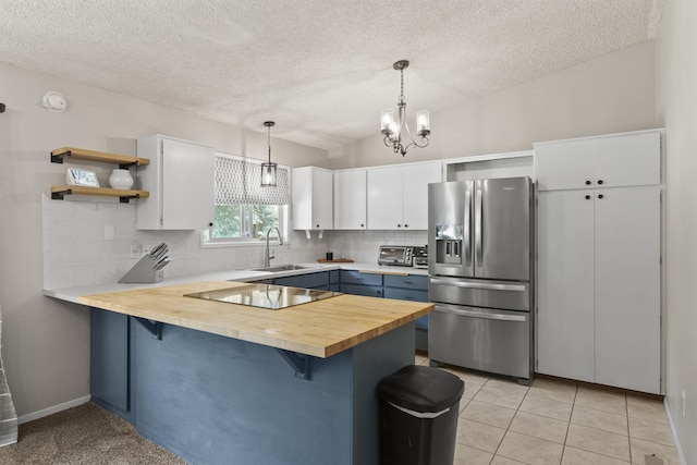3114 W 20th Ave, Spokane, WA 99224 - kitchen with stainless steel fridge, a peninsula, open shelves, a breakfast bar area, and backsplash