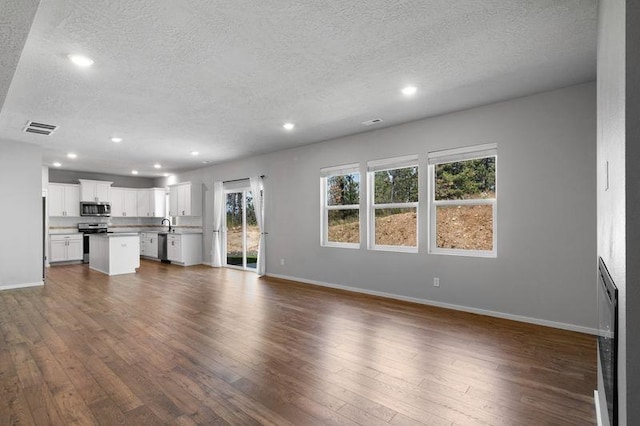12413 E Dickens Ln, Spokane Valley, WA 99206 - unfurnished living room featuring a textured ceiling, dark wood-style flooring, and recessed lighting
