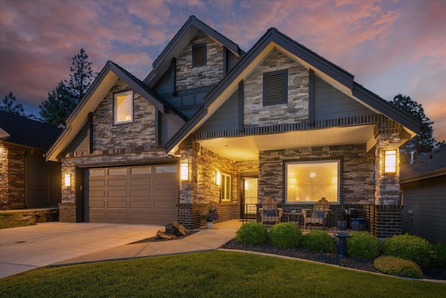 2605 S Cherrytree Ln, Spokane, WA 99203 - craftsman house featuring stone siding, an attached garage, concrete driveway, a front lawn, and a porch