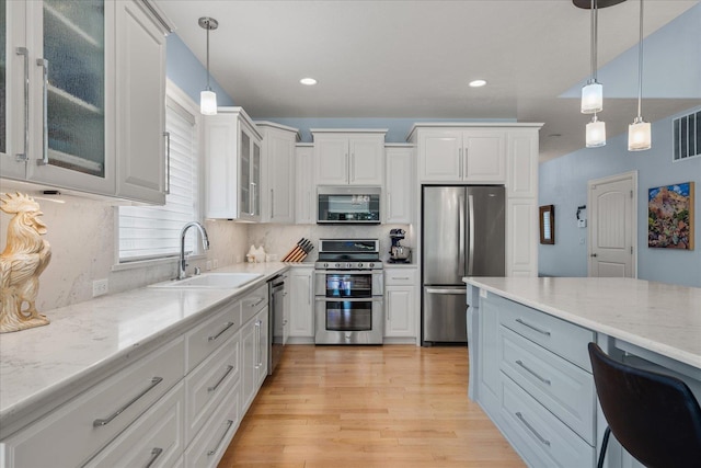 2605 S Cherrytree Ln, Spokane, WA 99203 - kitchen featuring stainless steel appliances, light stone counters, decorative light fixtures, light wood finished floors, and recessed lighting