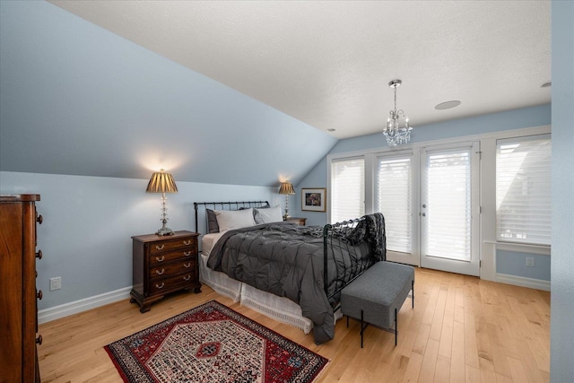 2605 S Cherrytree Ln, Spokane, WA 99203 - bedroom featuring access to exterior, light wood-style flooring, lofted ceiling, and a chandelier