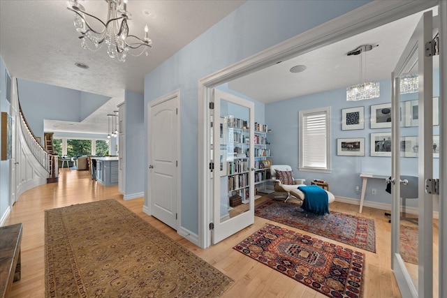 2605 S Cherrytree Ln, Spokane, WA 99203 - hallway with a chandelier, light wood-style floors, stairs, and a textured ceiling