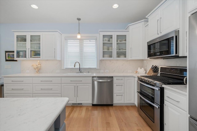 2605 S Cherrytree Ln, Spokane, WA 99203 - kitchen with stainless steel appliances, white cabinetry, light wood-style flooring, decorative backsplash, and recessed lighting