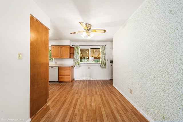 10914 E 7th Ave, Spokane Valley, WA 99206 - kitchen featuring white dishwasher, a ceiling fan, light wood-style floors, brown cabinets, and light countertops