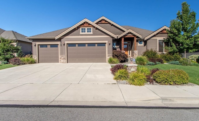 1119 N River Ridge Blvd, Spokane, WA 99224 - craftsman inspired home featuring stone siding, a garage, and driveway