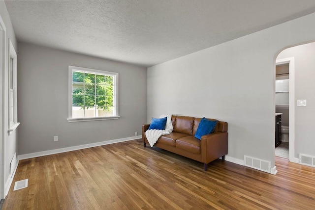 5130 N Stevens St, Spokane, WA 99205 - living area with arched walkways, wood finished floors, and a textured ceiling