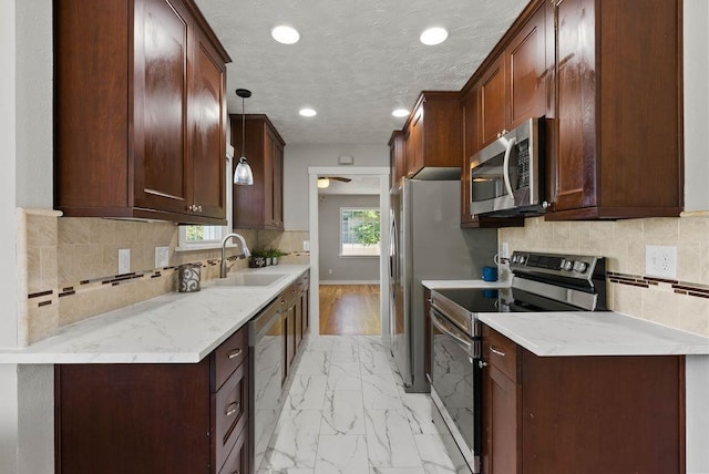 5130 N Stevens St, Spokane, WA 99205 - kitchen with appliances with stainless steel finishes, light marble finish floors, recessed lighting, backsplash, and hanging light fixtures