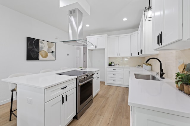 2009 W 9th Ave, Spokane, WA 99204 - kitchen featuring stainless steel range, island range hood, a kitchen bar, tasteful backsplash, and recessed lighting
