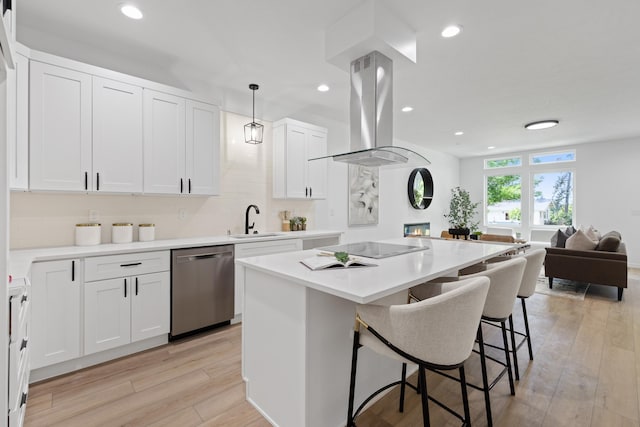 2009 W 9th Ave, Spokane, WA 99204 - kitchen featuring stainless steel dishwasher, island exhaust hood, a breakfast bar, a center island, and light wood-style flooring