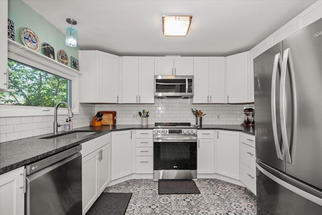 337 E 20th Ave, Spokane, WA 99203 - kitchen with stainless steel appliances, decorative backsplash, white cabinetry, and dark stone countertops