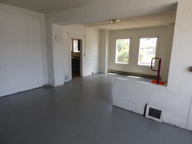 1727 E Riverside Ave, Spokane, WA 99202 - spare room featuring concrete floors and a baseboard radiator
