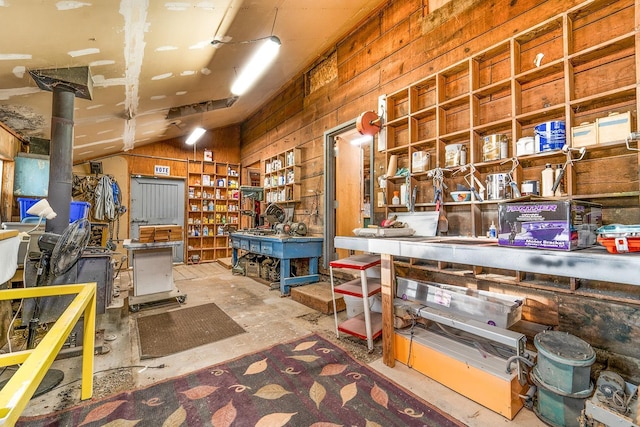 2420 S Cherry Ln, Spokane, WA 99223 - miscellaneous room featuring a workshop area, wood walls, vaulted ceiling, and unfinished concrete flooring